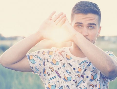 Man with green eyes holding the sun